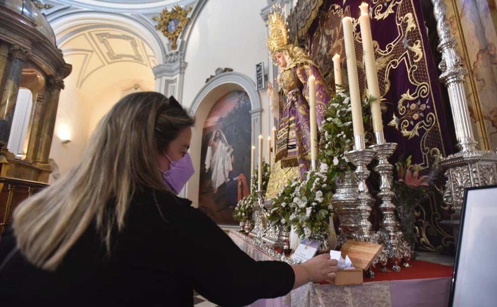 Una devota deposita uno de los papeles en el altar de la Virgen de Consolación y Lágrimas, en la iglesia de San Felipe Neri. 