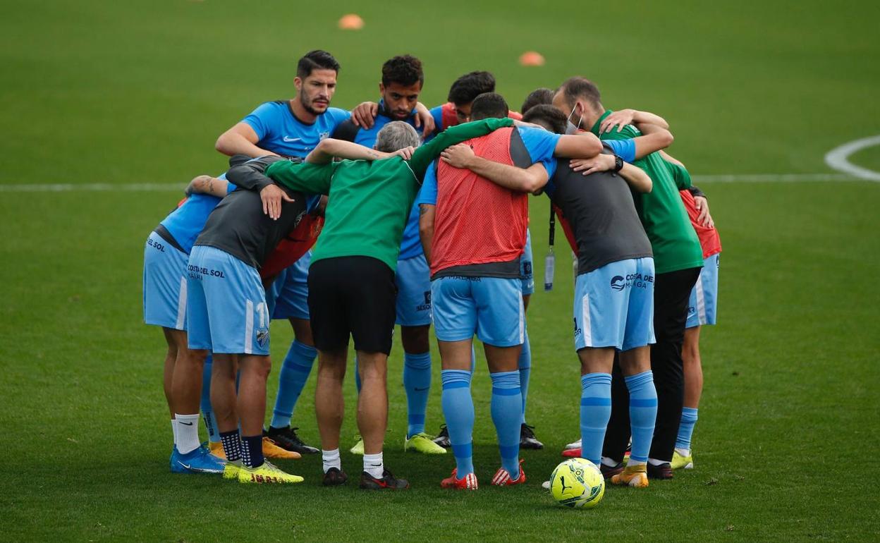 Los jugadores del Málaga hacen piña con los preparadores físicos al término del calentamiento previo al partido del martes ante el Almería. 