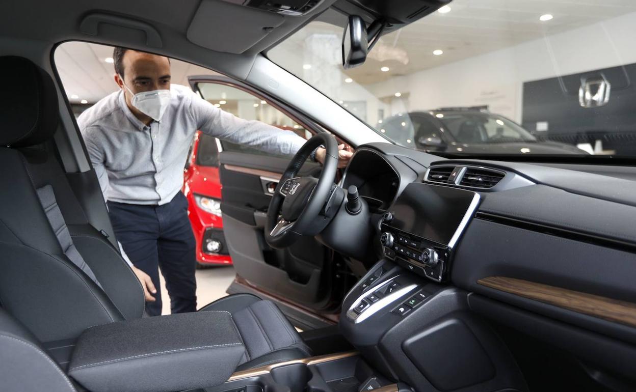 Un vendedor de coches con mascarilla en un concesionario Honda. 