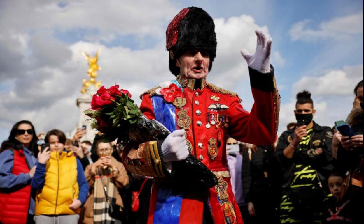 Un admirador de la monarquía británica coloca flores en recuerdo del duque de Edimburgo frente al palacio de Holyroodhouse.