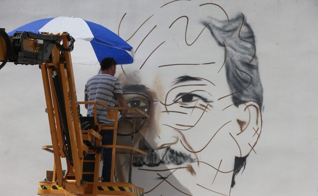 La imagen muestra al arista urbano Nesui SRC trazando líneas del grafiti de José María Martín Carpena.