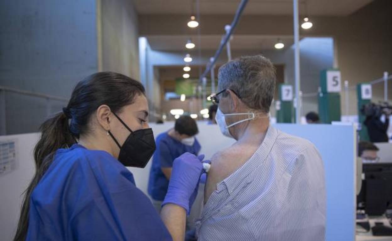 Una enfermera administra una vacuna a un paciente