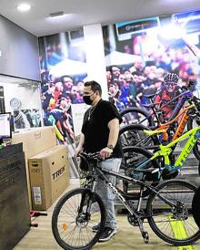 Imagen secundaria 2 - Una familia atraviesa uno de los senderos de los Montes de Málaga en bicicleta. Dos personas practican el 'nordic walking', disciplina que hace con ayuda de bastones para acompañar la marcha con un braceo. Una imagen tomada en la tienda de Trek Málaga. 