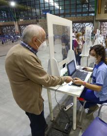 Imagen secundaria 2 - Ciudadanos accediendo al Palacio de Ferias y toma de la temperatura al entrar. 