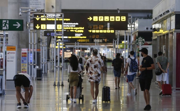 Turistas se dirigen a los controles de seguridad del aeropuerto de Málaga. 