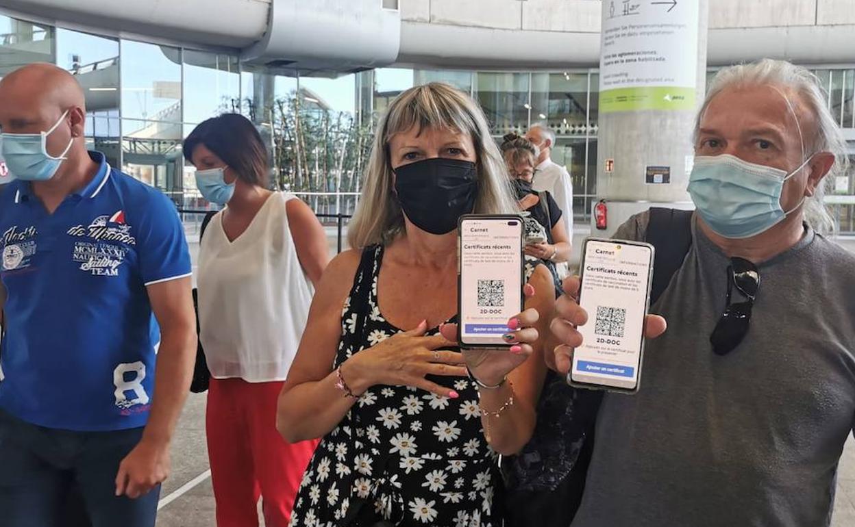 Turistas muestran a la llegada al aeropuerto de Málaga su código QR en el que se recoge la vacunación. 