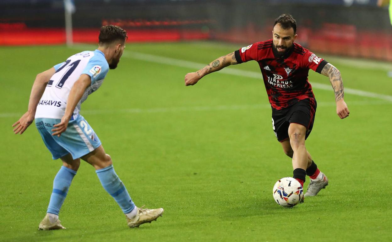 El jugador Javi Jiménez, con el Mirandés, encara al jugador del Málaga, Iván Calero, en La Rosaleda en la temporada 20-21.