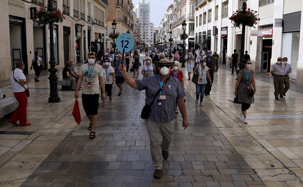 Un grupo de cruceristas del Mein Schiff 2 de TUI camina por la calle Larios, junto a Daniel Stachel, guía autorizado que trabaja por primera vez después de 15 meses. 