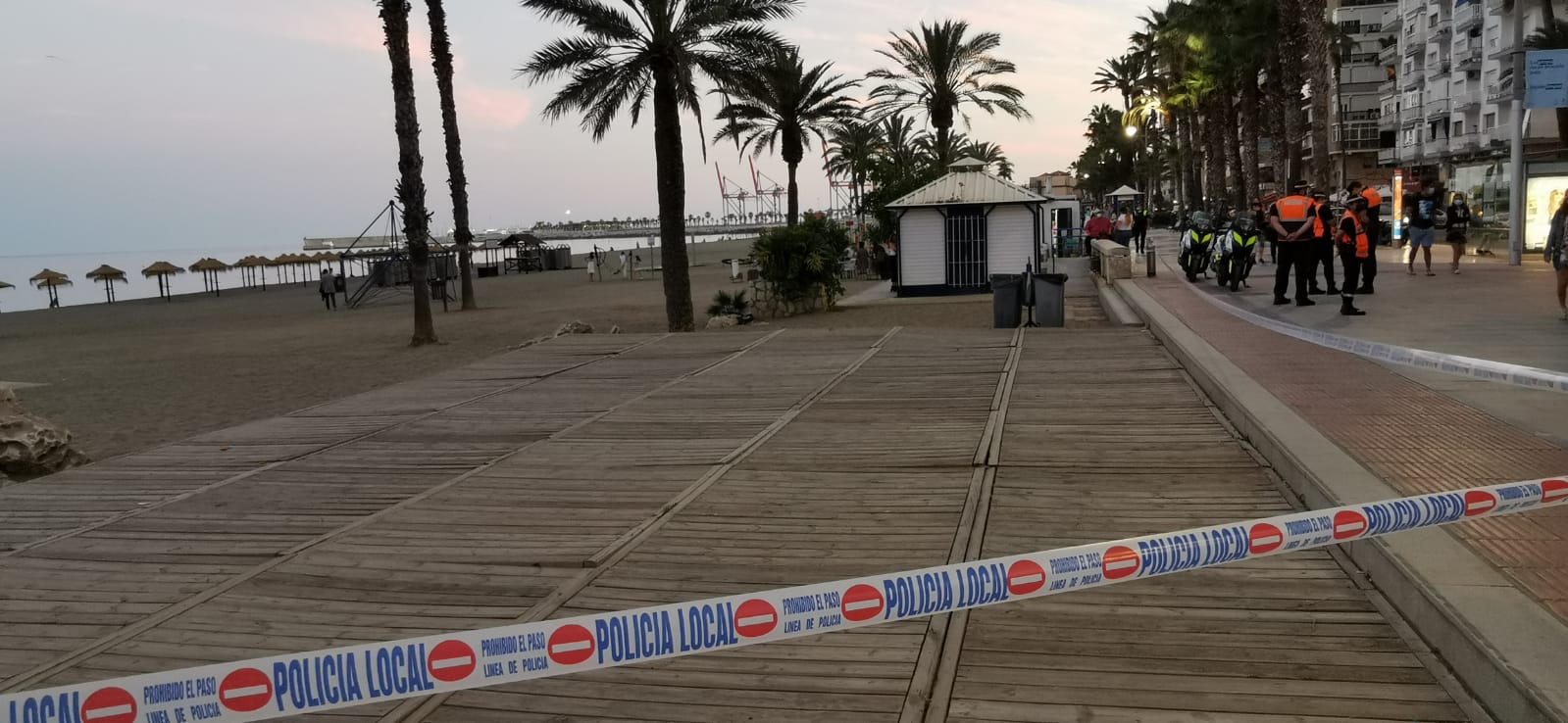 La Policía pone cintas para impedir el acceso a la arena e informa sobre la prohibición de entrar durante toda la noche
