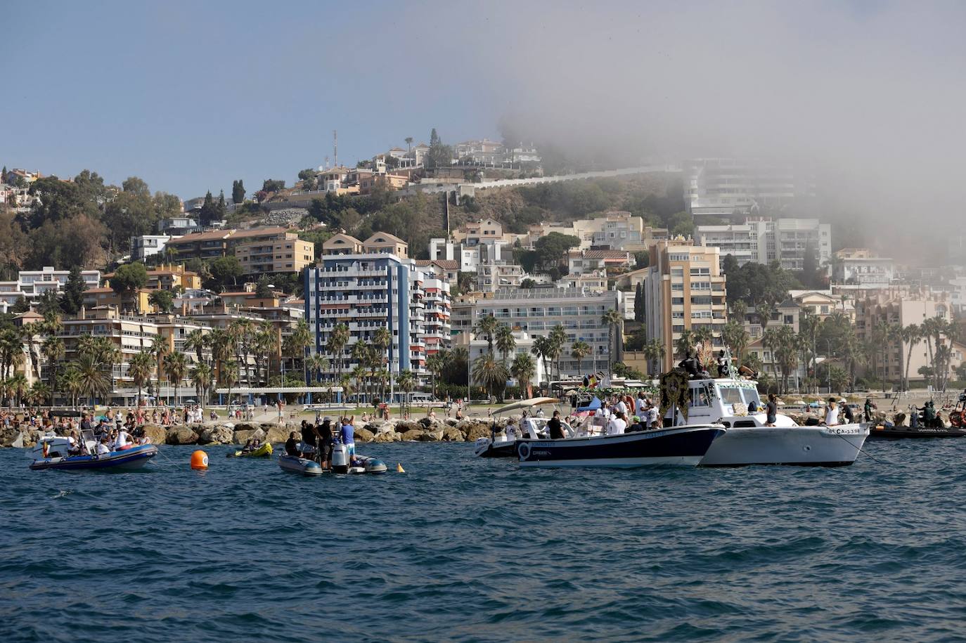 El estandarte ha sido llevado hasta el Puerto de la capital, donde en la casa de botes del Club Mediterráneo ha embarcado para dirigirse hacia las playas de La Malagueta.