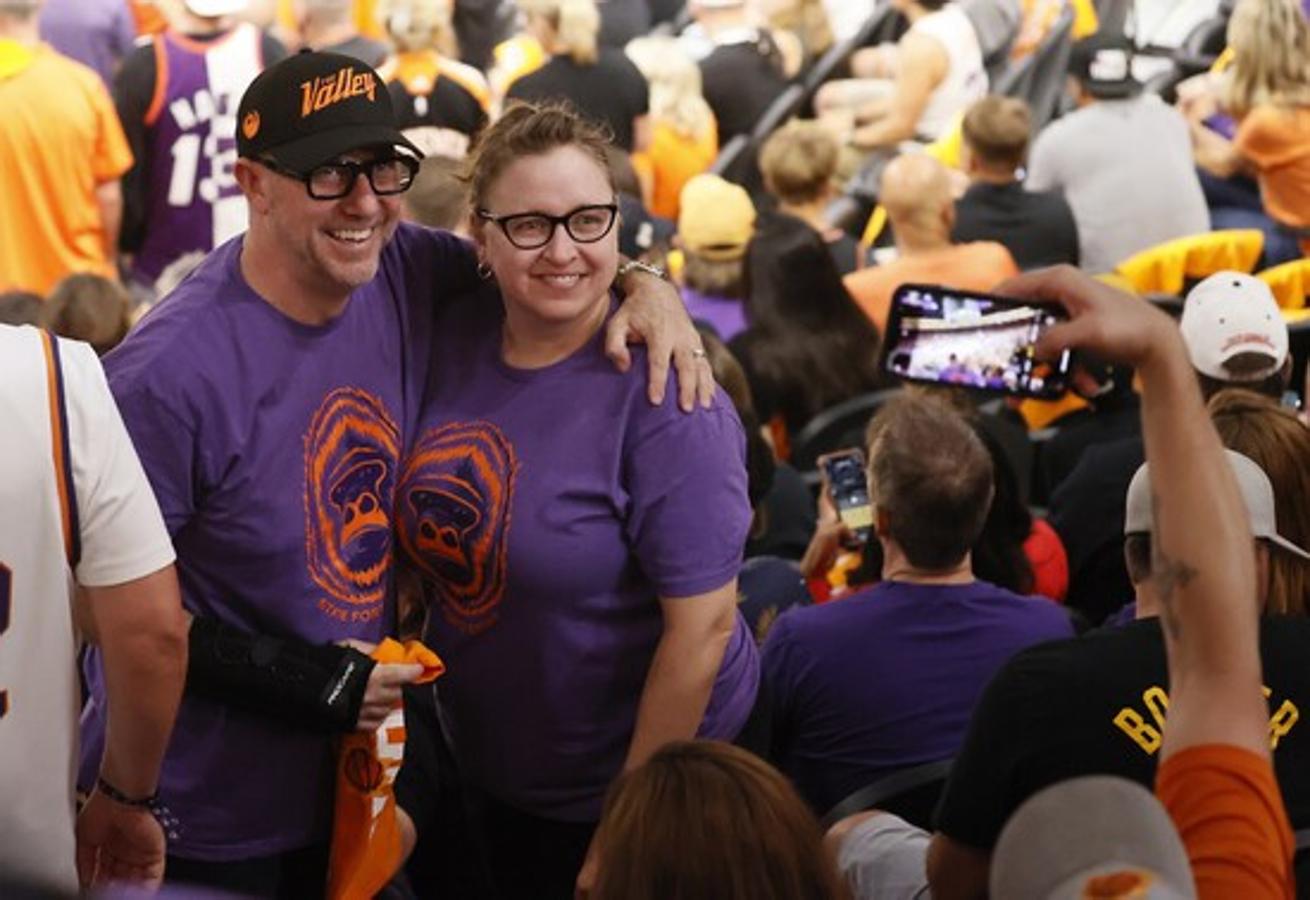 Una pareja de fans de los Suns se toman una foto instantes antes del inicio del partido. 