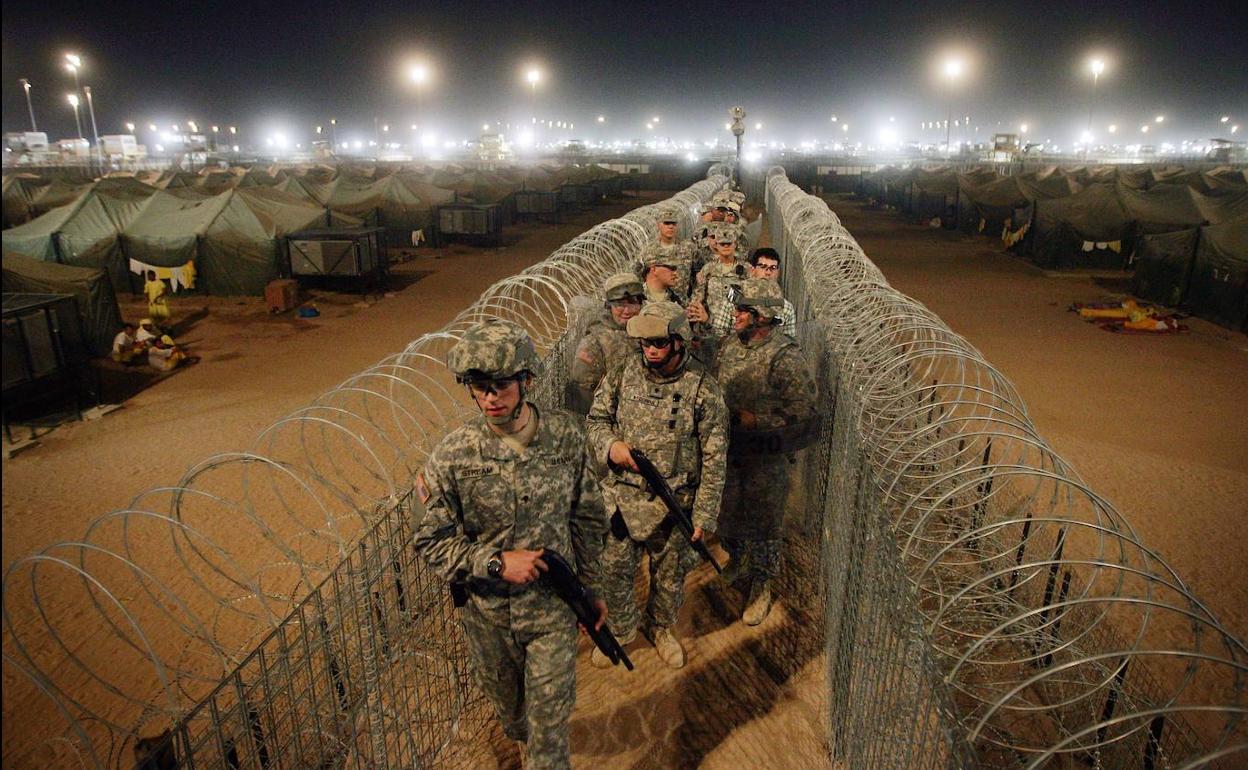 Soldados de EE UU llevan escopetas mientras caminan por un corredor en un centro de detención, cerca de la frontera entre Kuwait e Irak.