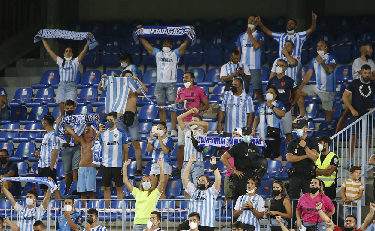 Aficionados malaguistas apoyan al equipo con bufandas en alto en el duelo ante el Alcorcón de esta campaña. 