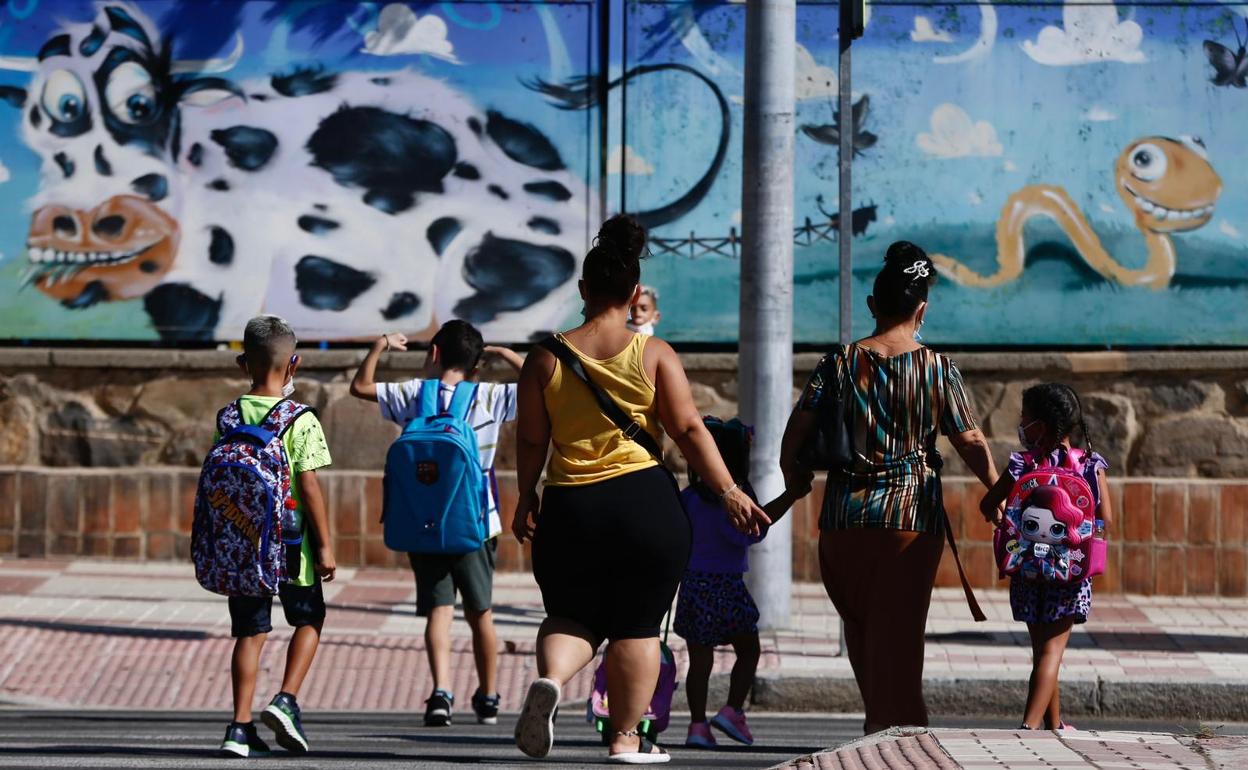 Madres y niños se dirigen al colegio en el primer día del nuevo curso escolar. 