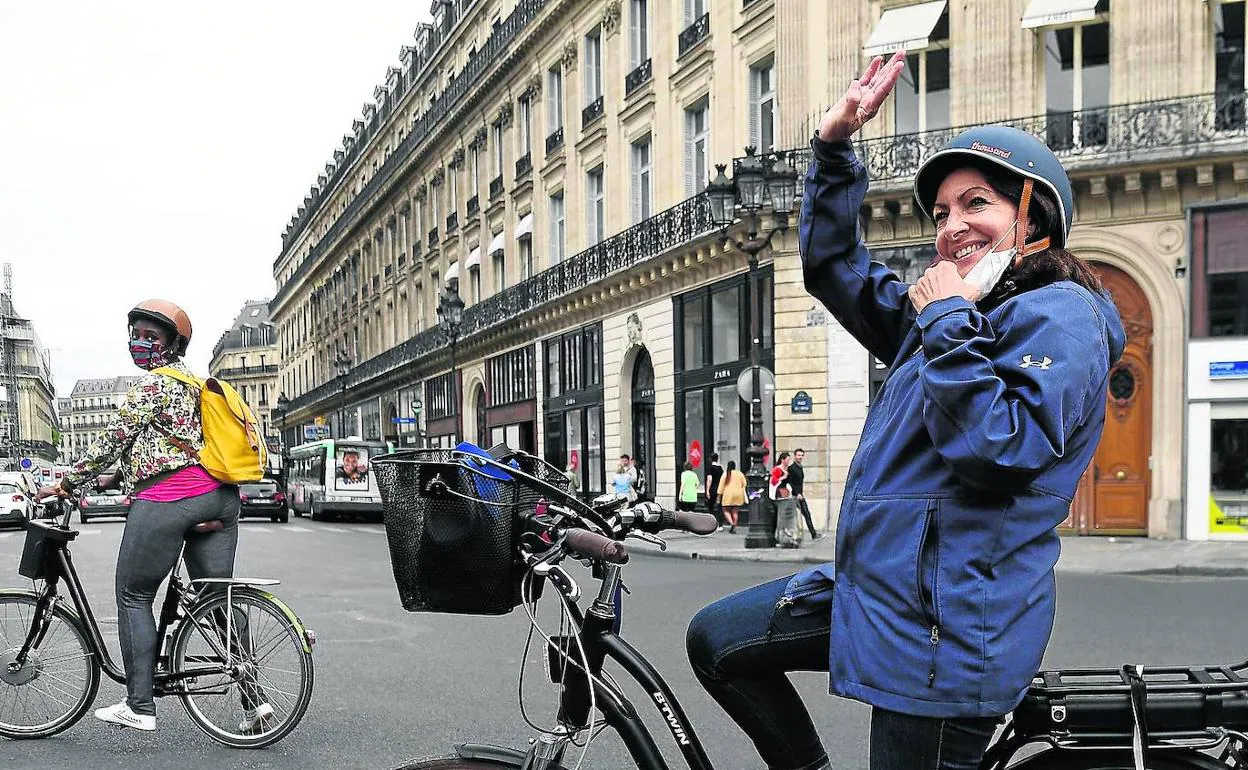 Anne Hidalgo saluda a unos parisinos durante un paseo en bicicleta por el centro de la capital francesa. 