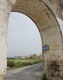 Imagen secundaria 2 - Arriba: Vista general de uno de los tramos del Acueducto de la Fuente del Rey. Abajo, por algunos de sus arcos pasan caminos asfaltados e incluso calles. En algunos puntos este acueducto ha servido como estructura para viviendas 