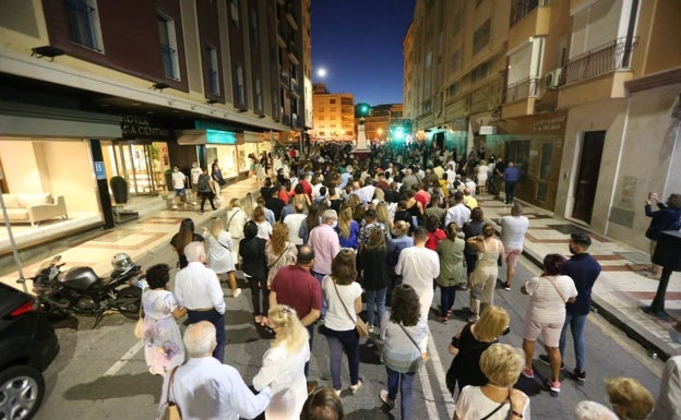 Personas de promesa tras la imagen de Jesús Cautivo, en la calle Mármoles. 