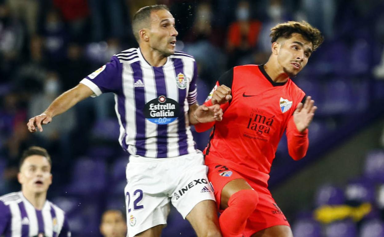 El jugador del Málaga, Kevin, pugna por un balón con Nacho, del Valladolid.