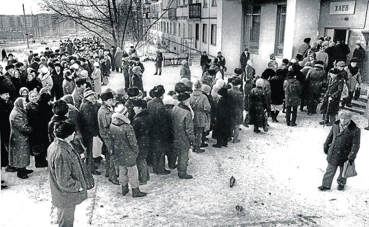 La cola del pan. Numerosas personas esperan para comprar el pan en Cheliábinsk, en el año 1985. Muebles y enseres en la escalera. 