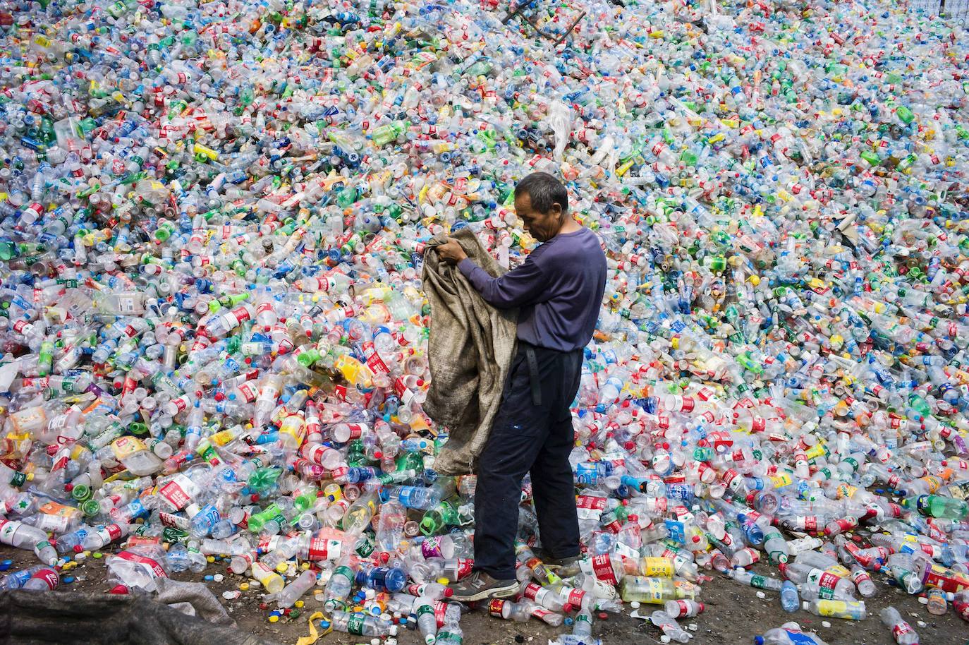 Un trabajador chino clasifica botellas de plástico para reciclarlas en la aldea de Dong Xiao Kou, en las afueras de Beijing. China es el mayor emisor del mundo de gases de efecto invernadero que causan el cambio climático