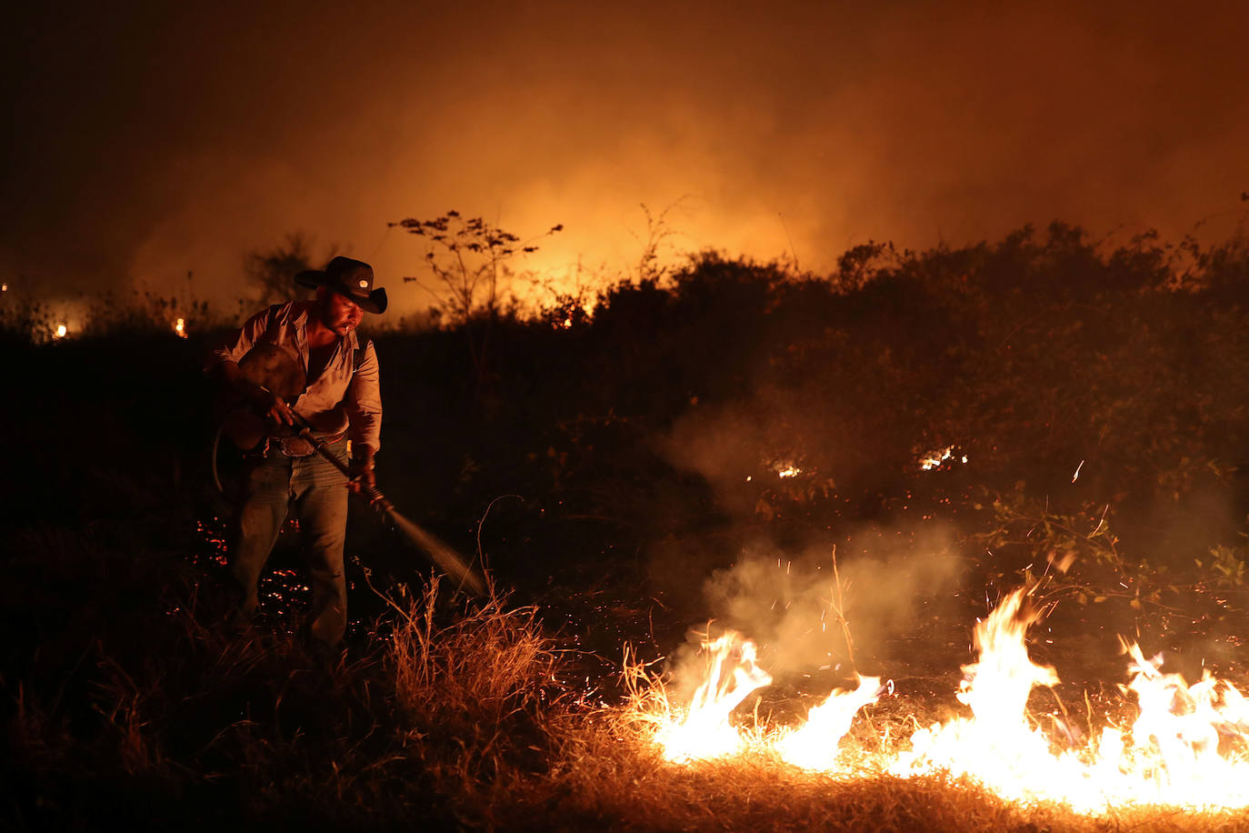 Sebastiao Baldi Silva Junior, de 40 años, que trabaja en una granja, intenta apagar un incendio en un rancho en el Pantanal, el humedal más grande del mundo, en Pocone, estado de Mato Grosso, Brasil.