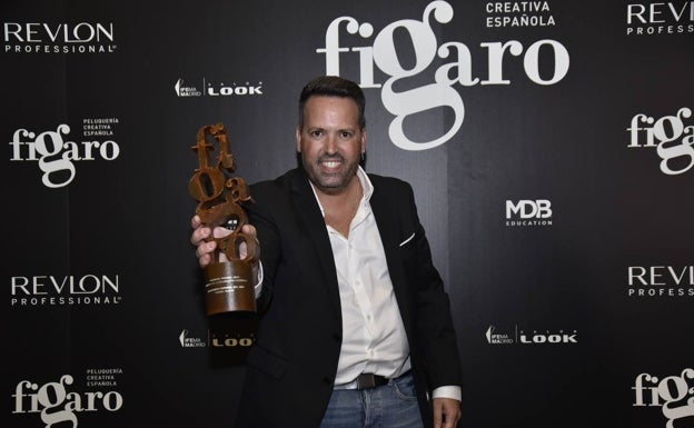 Rafael Bueno sostiene s premio en los Premios Fígaro.