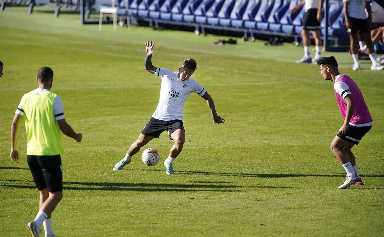 El jugador del Málaga, Brandon Thomas, conduce el balón ante Ismael Gutiérrez en un entrenamiento de esta semana en La Rosaleda.