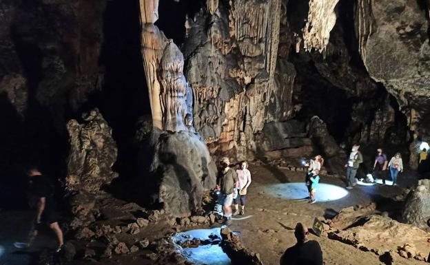 Imagen principal - Grupo visitando la Cueva de Ardales. Abajo, representación de una cabra en la Cueva del Higuerón y página dedicada a la Cueva de Ardales en la revista L'Anthropologie.