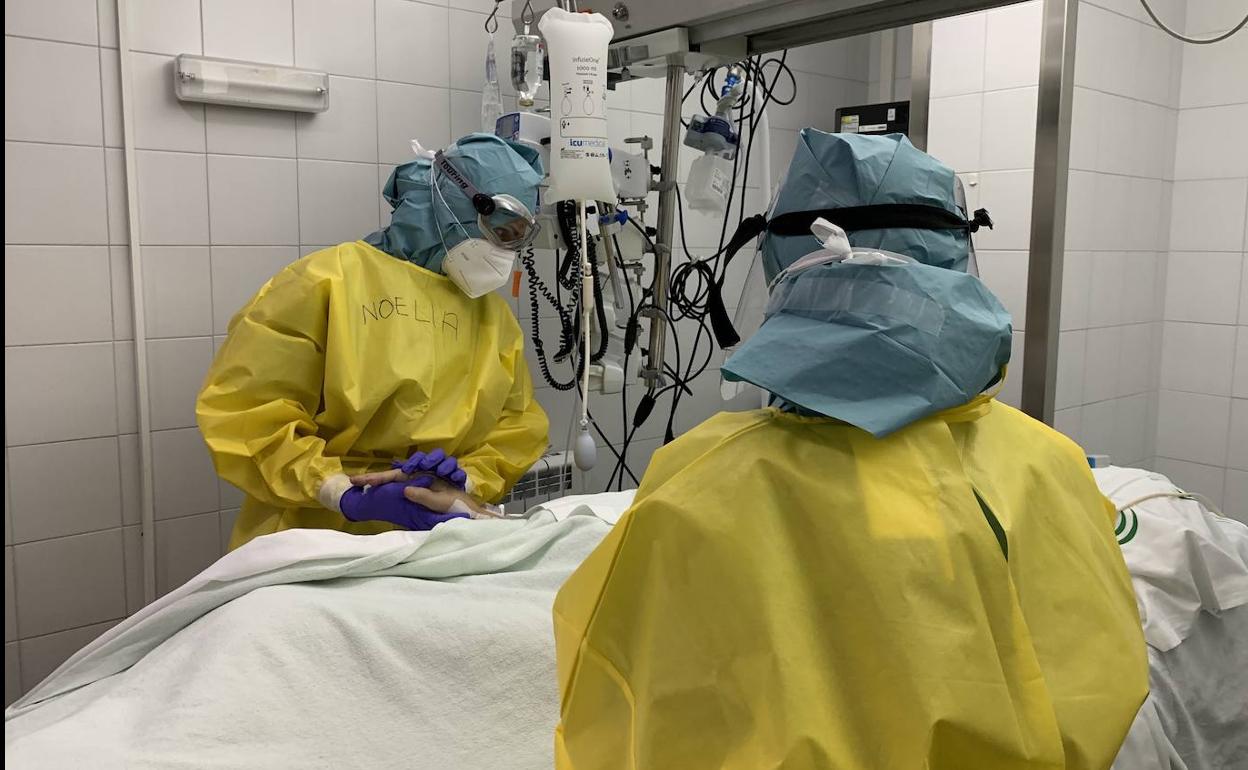 Dos sanitarios con un paciente. 