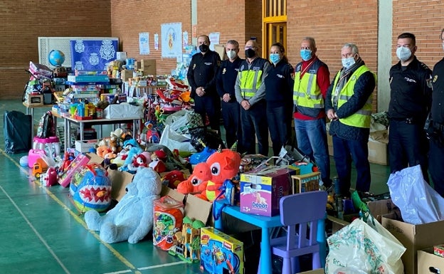 Miembros de La Biznaga Azul y responsables de la Policía con algunos de los donativos.