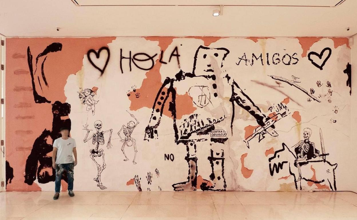 El artista Dadi Dreucol, junto a su mural creado en la pared del Museo Picasso de Málaga. 