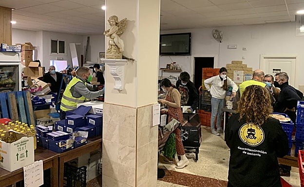 Imagen principal - Solidaridad bajo la lluvia: los Ángeles Malagueños de la Noche no fallan en Nochebuena