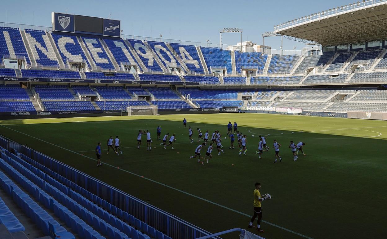 Jugadores del Málaga se ejercitan sobre el césped de La Rosaleda en un entrenamiento de esta temporada.