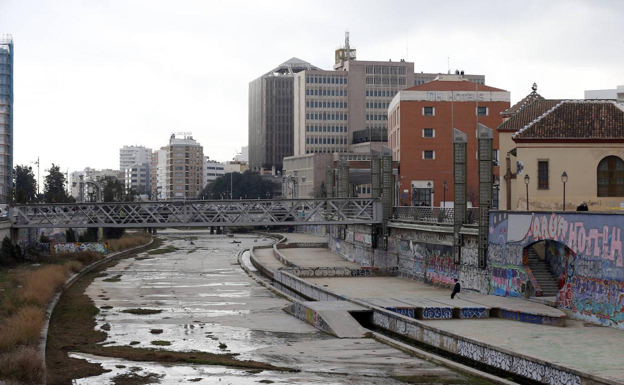 Aspecto que presenta el cauce, con matojos, agua estancada, pintadas y cristales rotos. 