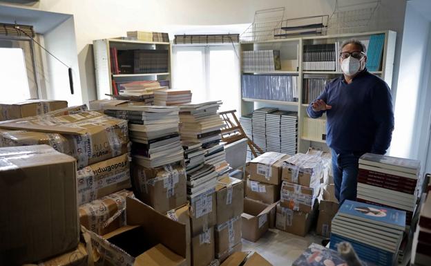 Imagen principal - Arriba, el director de Proteo, Jesús Otaola, junto a los libros que han entrado ya en la restaurada sede de la librería. Abajo, la primera planta donde esta semana se rematan los últimos trabajos de la rehabilitación. A la derecha, detalle de la muralla de la ciudad en el interior del local que ha quedado oscurecida por el fuego del pasado mes de mayo. 