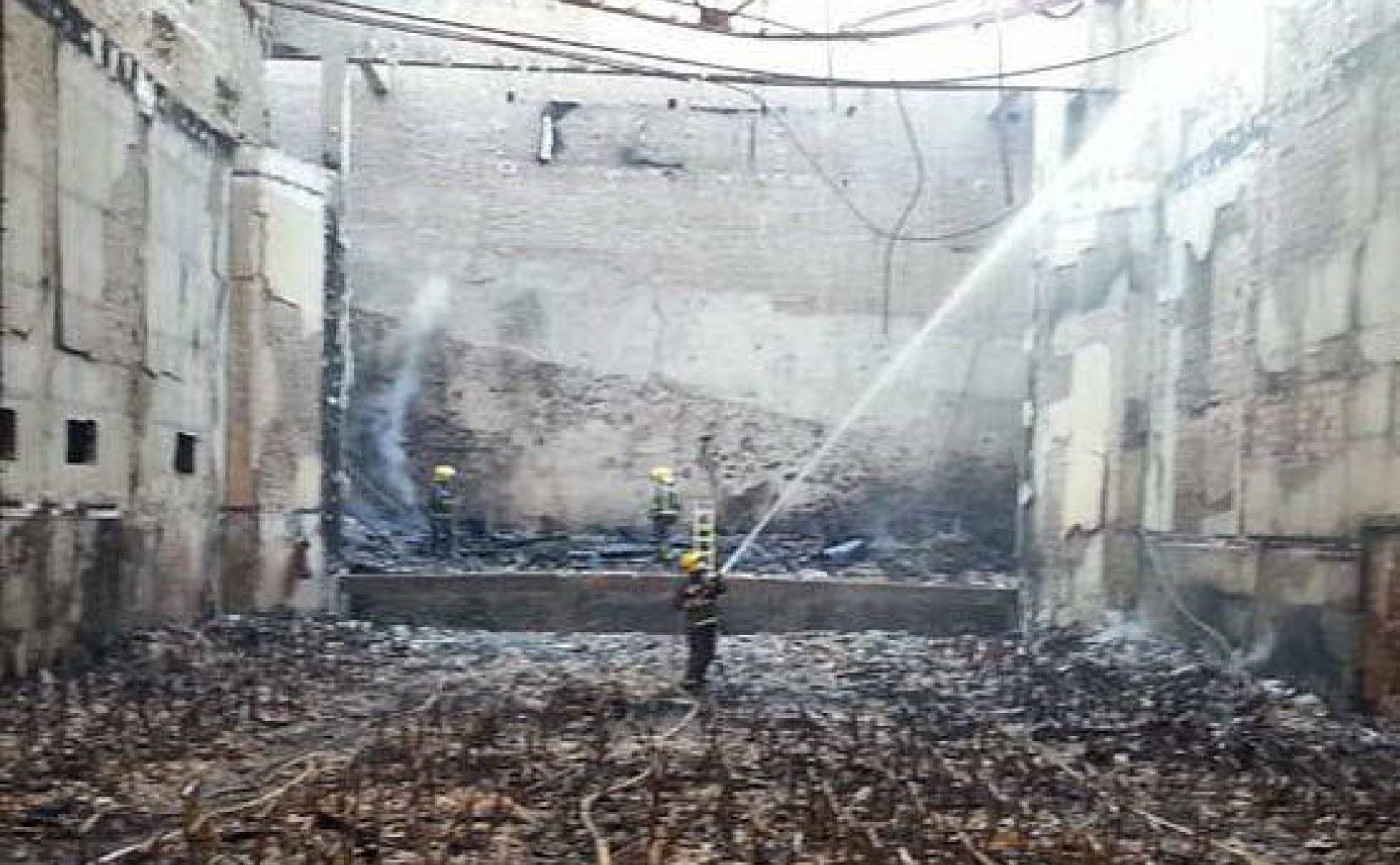 Bomberos realizan labores de refresco tras quedar arrasado lo que fue el patio de butacas del cine Andalucía el 15 de marzo de 2014. 