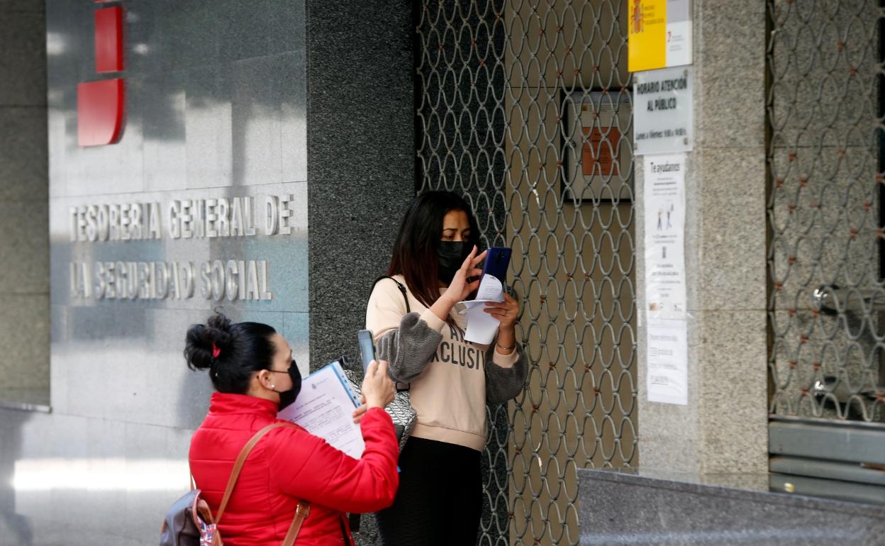 Dos ciudadanos que quieren realizar un trámite en la Tesorería de la Seguridad Social se topan con la puerta cerrada, una constante desde la pandemia. 
