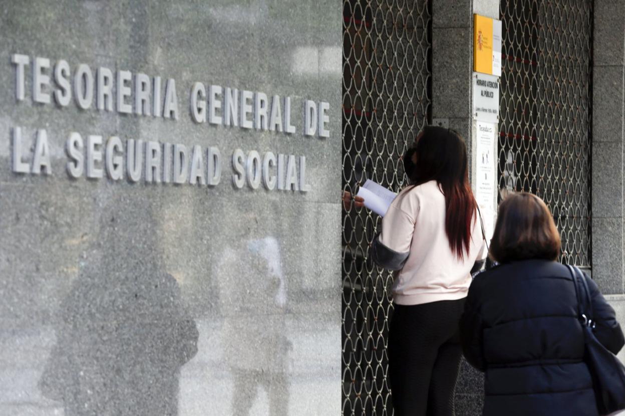 Dos personas, a las puertas de la sede de la Seguridad Social en la capital. 