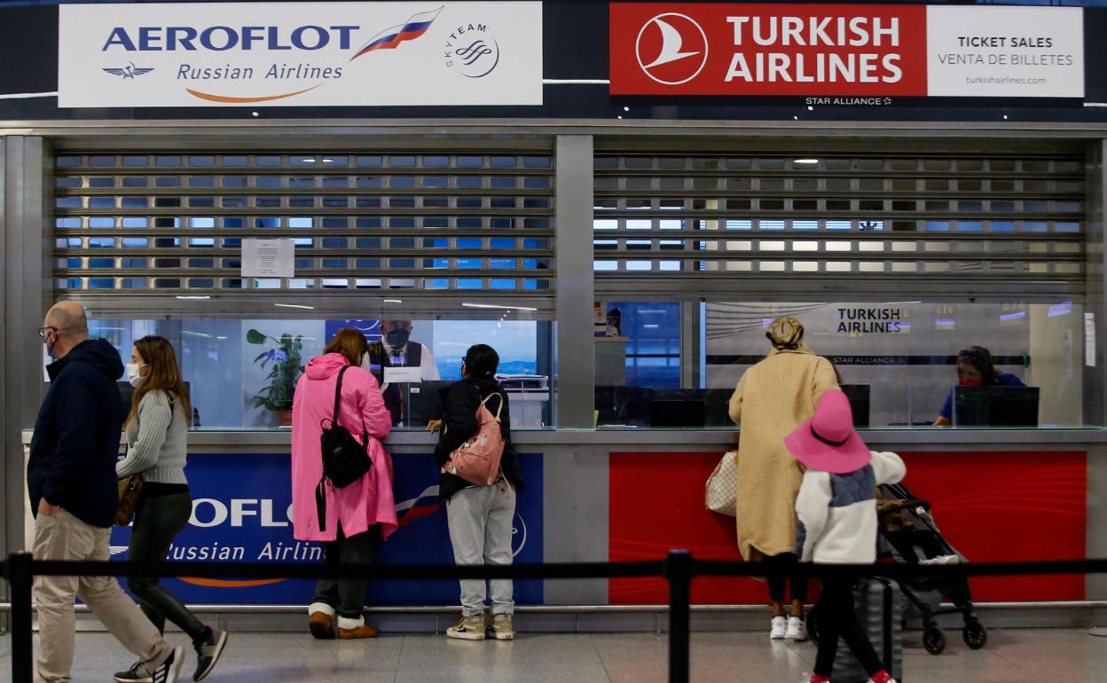 Una pareja, que reside en la Costa del Sol, consulta en la ventanilla de Aeroflot en el aeropuerto. 