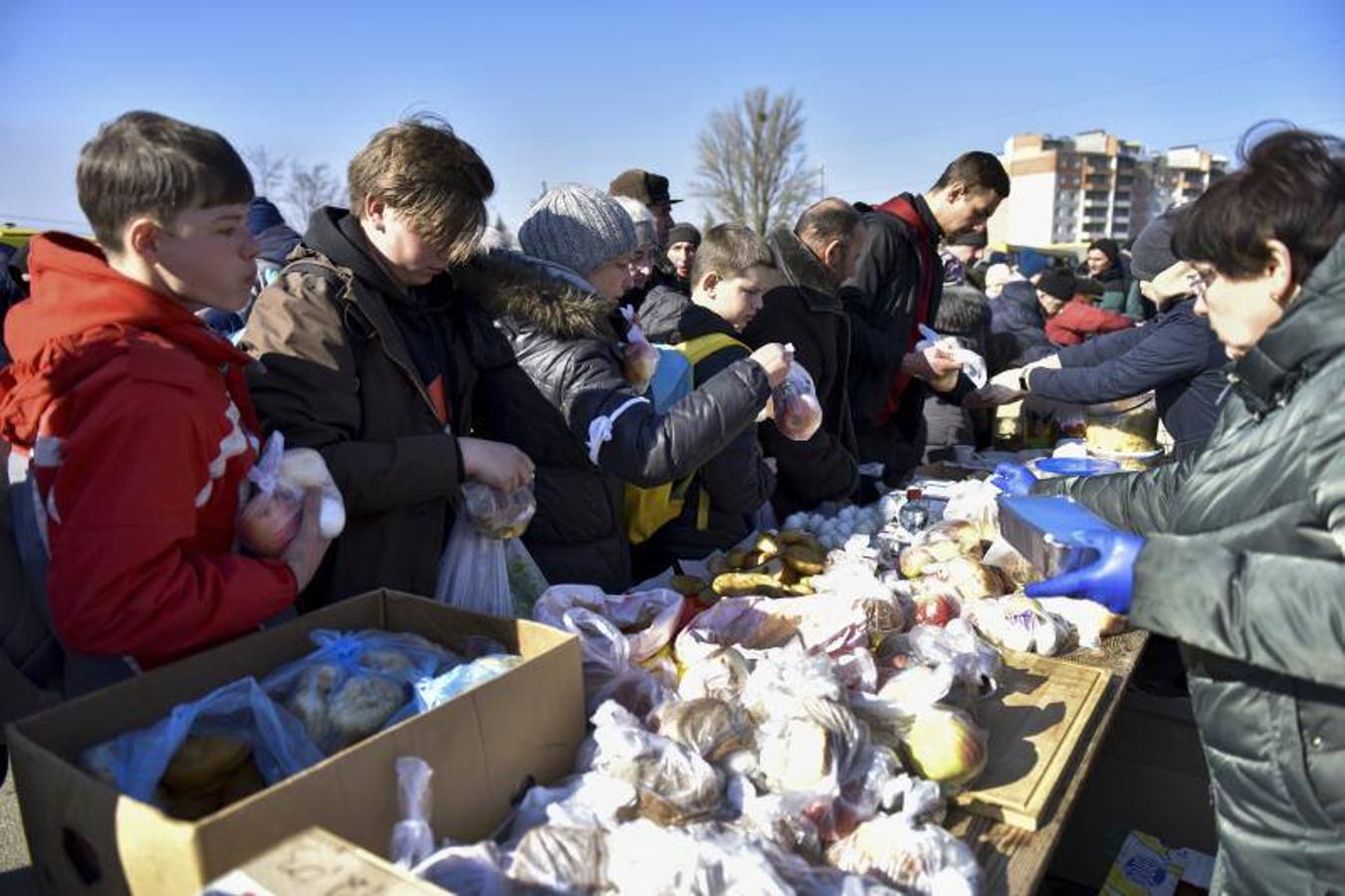 Personas reciben alimentos después de haber sido evacuadas de un pueblo cercano a Kiev ocupado por el ejército ruso.