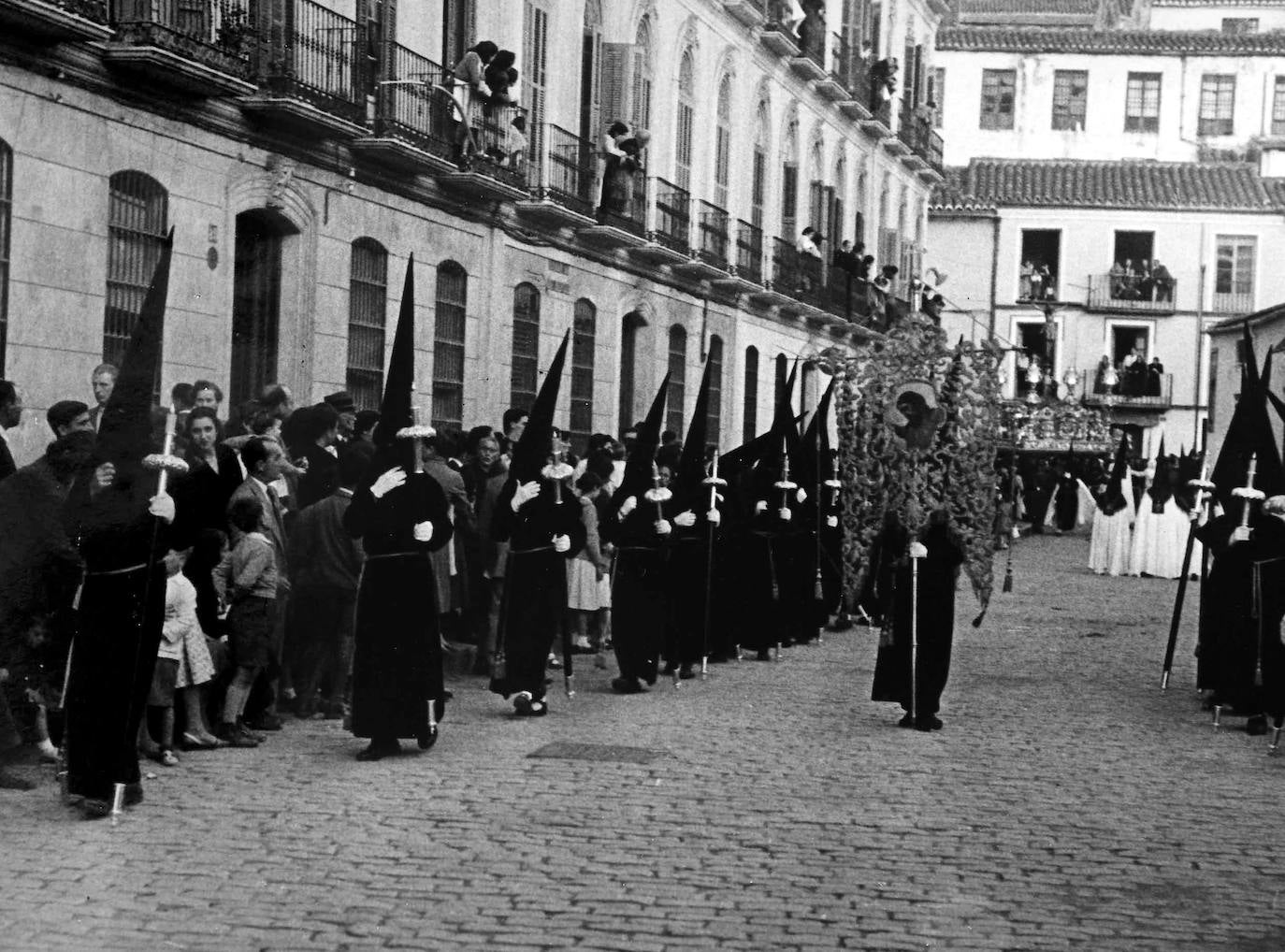 Años cincuenta. El cortejo de nazarenos del Cristo del Amor, en la plaza de la Merced. 