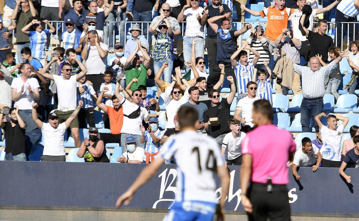 Aficionados del Málaga celebran en La Rosaleda durante el partido de este sábado contra el Valladolid.