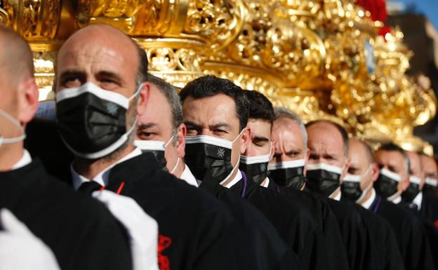 Juanma Moreno, llevando el trono este Miércoles Santo por Málaga.