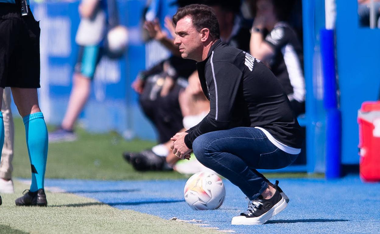 Pablo Guede, en cuclillas durante el partido del Málaga en Leganés.