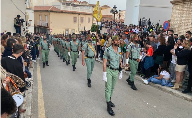 Imagen principal - Arriba, La Legión, acompañando a la Virgen de las Angustias Coronada; debajo, a la izquierda, el Cristo del Mar y María Santísima de las Penas; y a la derecha, la Virgen de la Caridad, en la plaza de la Constitución. 