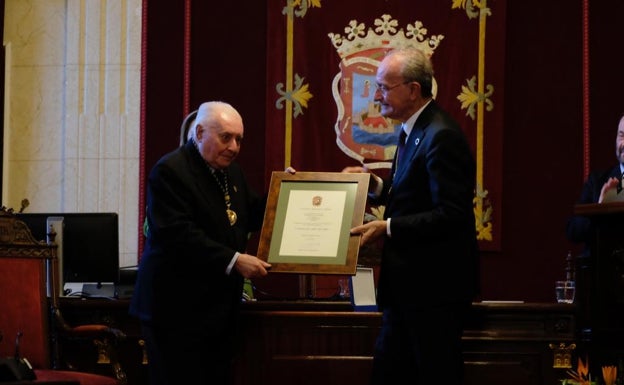 Del Campo muestra a los presentes el documento que le entrega el alcalde de Málaga, Francisco de la Torre, donde se acredita que es Hijo Predilecto de la Ciudad.