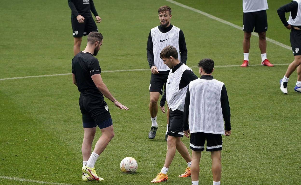 El jugador del Málaga, Genaro, en el entrenamiento de este viernes en La Rosaleda junto a otros compañeros.