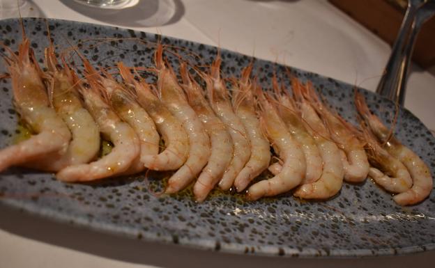 Imagen principal - En la primera foto, gambas con su pilpil. No son gambas al pilpil, todo lo contrario. Se trata de gambas malagueñas de tamaño mediano, levemente plancheadas y acompañadas de un suave pilpil que está aparte. El maridaje, un amontillado jerezano. En la segunda foto, alcachofas con chopitos y jamón. ¿Qué fue antes, la alcachofa o el chopito? Un dilema no resuelto, pues tanto las alcachofas como los chopitos están excepcionales por su punto de fuego y por la calidad del producto. En la última imagen, pluma ibérica. En Araboka usan la de Dehesa los Monteros acompañada de patatas y salsa pesto rojo. La carne previamente ha sido marinada, lo que le oporta más sabor.