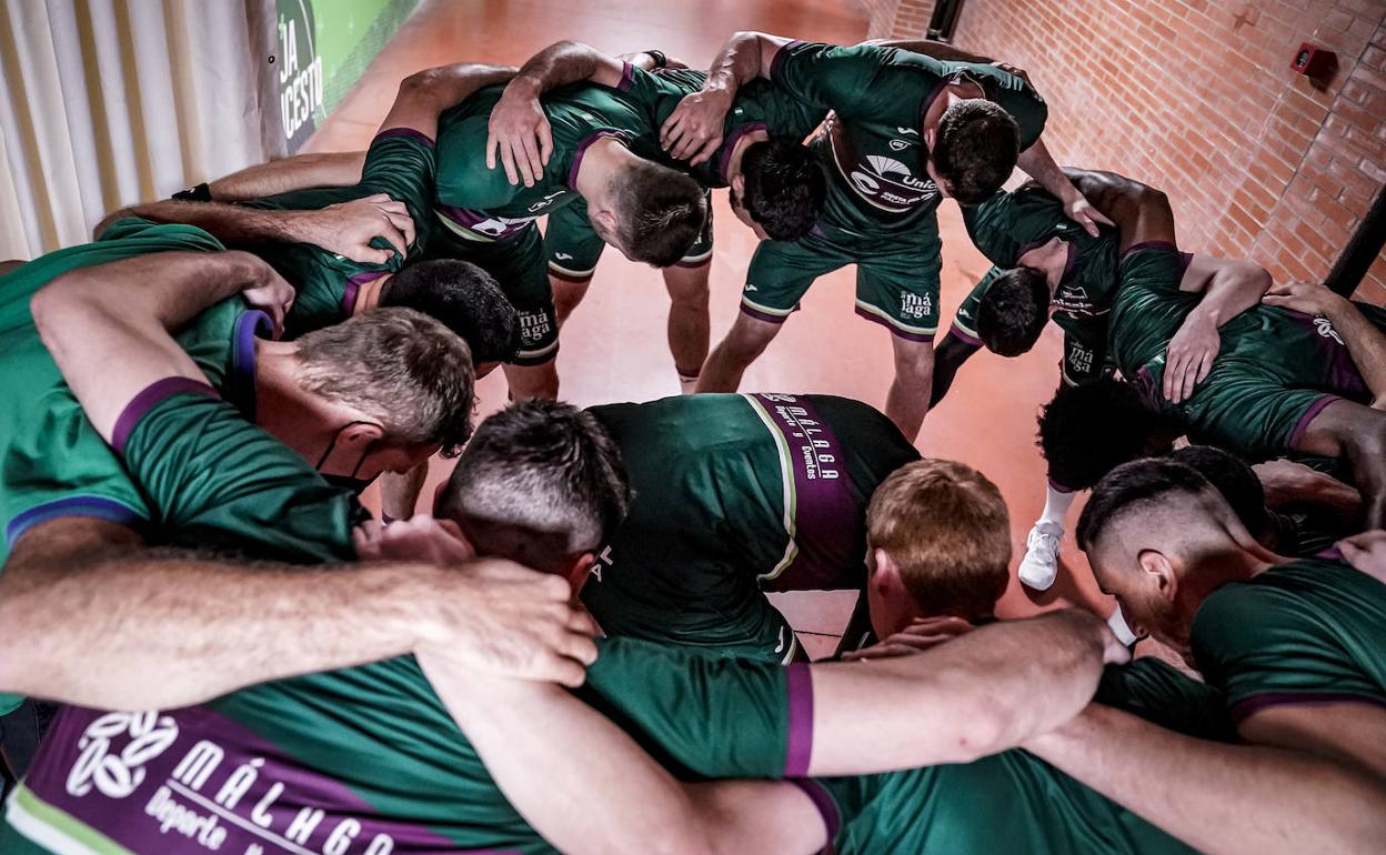 La piña de los jugadores del Unicaja antes de saltar a la pista en el Martín Carpena. 