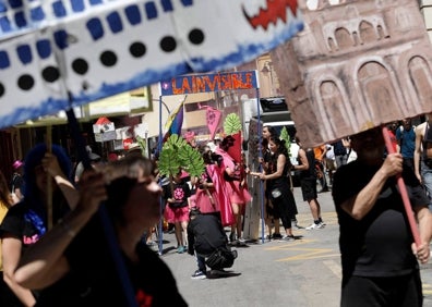 Imagen secundaria 1 - Arriba, la marioneta que hacía una crítica del poder, y sobre estas líneas manifestantes y el actor Joaquín Núñez, vestido de marengo. 